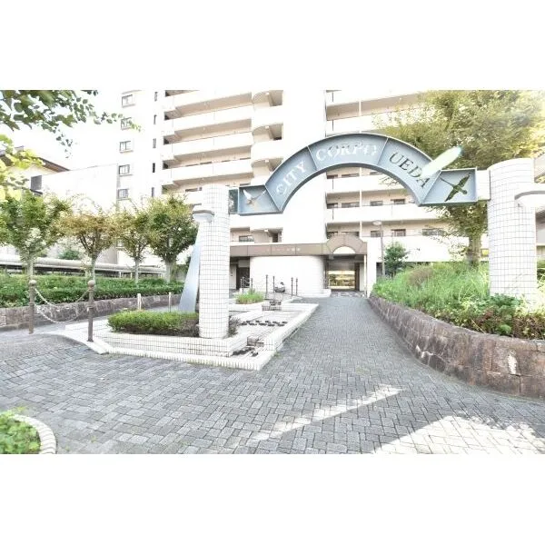 シティコーポ植田Ｂ棟 マンションメインメントランス。植栽を施しスチールの館銘板の重厚感があります