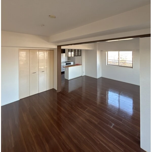 ライオンズステーションタワー松戸 南東向き洋室約7.8畳とリビング・ダイニング、キッチンカウンター