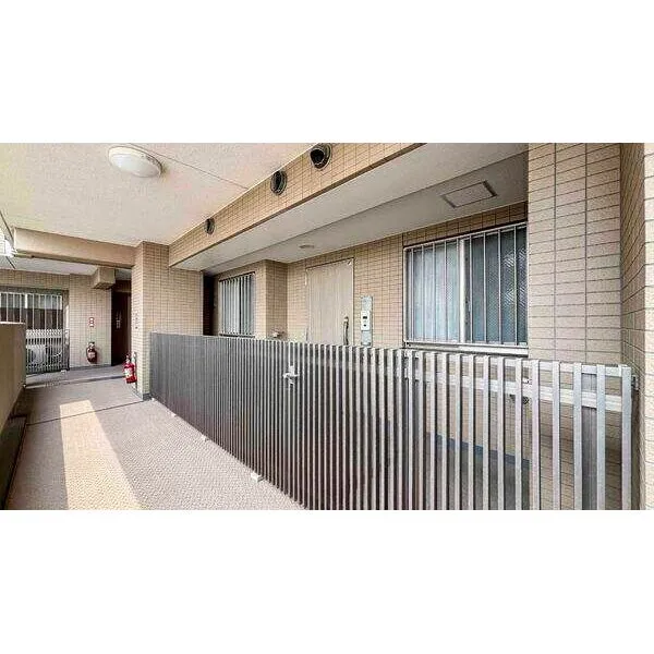 コスモ北新横濱ステーションフロント 玄関前には格子状の扉が設けられ、防犯面に配慮されています。モニタ付きインターホンも備わっています。