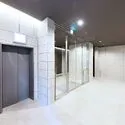 オープンレジデンシア本郷後楽園 ロビー：白のタイルでデザインされたロビー オートロック／エレベーター1基